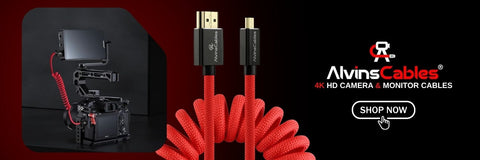 Red coiled HDMI camera and monitor cable with black connectors, shown alongside a camera rig inset and the AlvinsCables brand logo on a black and dark red background.