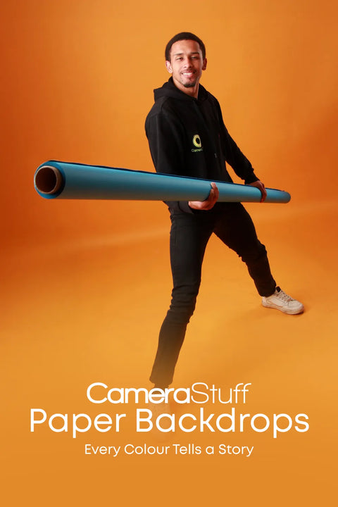 Man holding a blue backdrop with 'CameraStuff' branding on an orange background